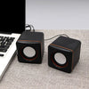 Mini USB Wired Speaker PC Speaker next to a laptop on a table, showcasing its compact design and modern style.