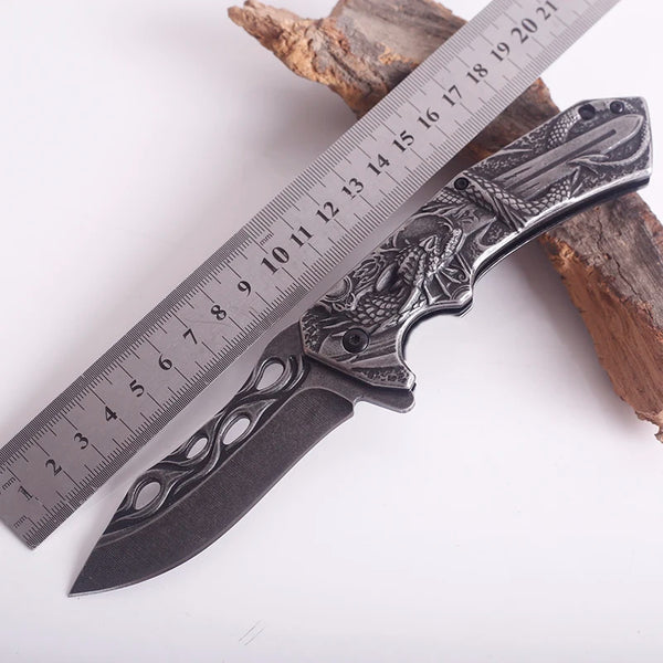 3D Embossed Dragon Folding Survival Knife displayed next to a ruler for size comparison