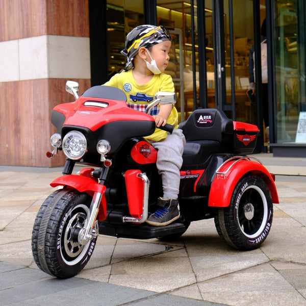 Child riding a 12V Plastic Powered Big Size Electric Motorbike in red color, showcasing outdoor play and stability on three wheels.