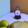 Rechargeable LED Camping Lamp with Bluetooth Speaker on a table with green apples.