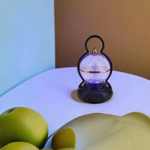 Rechargeable LED Camping Lamp with Bluetooth Speaker on a table with green apples.