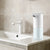 Automatic Soap Dispenser next to a modern sink in a clean bathroom setting.
