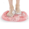 Feet standing on a pink Soft Body Massage Bath Brush for gentle exfoliation and cleansing in the shower.