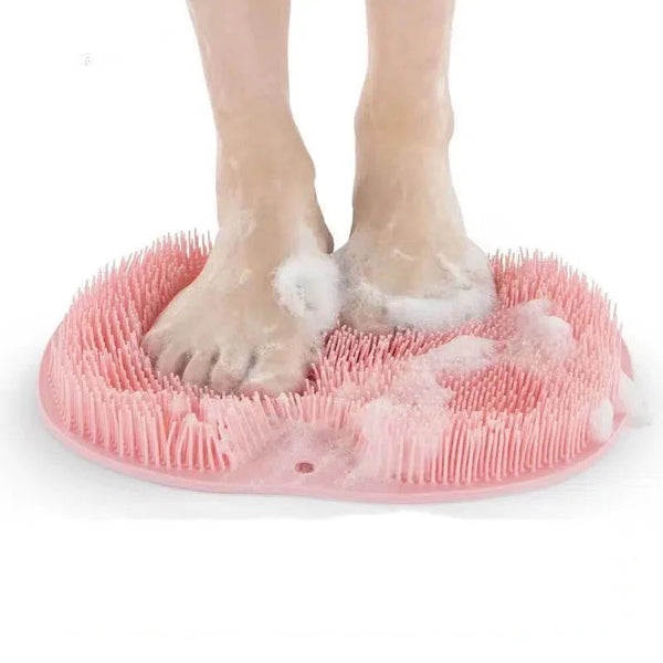 Feet standing on a pink Soft Body Massage Bath Brush for gentle exfoliation and cleansing in the shower.