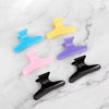 12 Piece Butterfly Hair Sectioning Clips in various colors on a marble surface, perfect for styling hair.