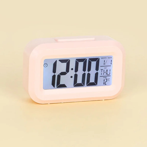 Smart Digital LCD Desk Clock with Temperature Display showing time, date, and temperature on a pink background.