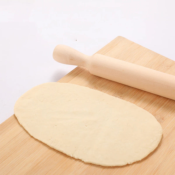 Wooden Rolling Pin next to rolled out dough on a bamboo surface for baking purposes.
