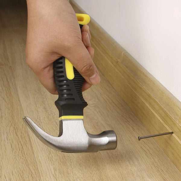 8oz Stubby Claw Hammer with Magnetic Nail Starter being used to drive a nail into wooden flooring.