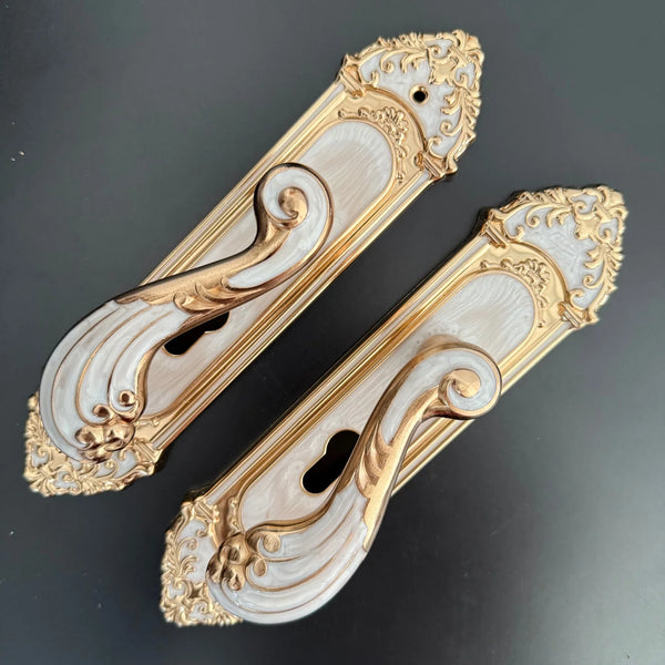 Modern White European Door Handle set featuring ornate design with gold accents on a sleek background.