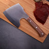 Handmade Forged Heavy Duty Cleaver on a cutting board next to sliced meat.