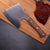 Handmade Forged Heavy Duty Cleaver on a cutting board next to sliced meat.