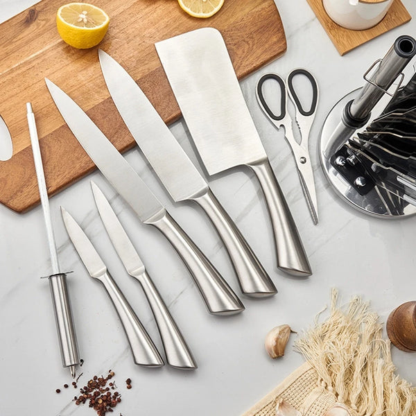 Stainless Steel 8 Piece Kitchen Knife Set displayed on a kitchen counter with various food preparation tools.