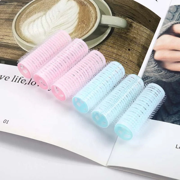 Plastic Hair Curlers Rollers 6pcs in pink and blue on a magazine with a coffee cup in the background.