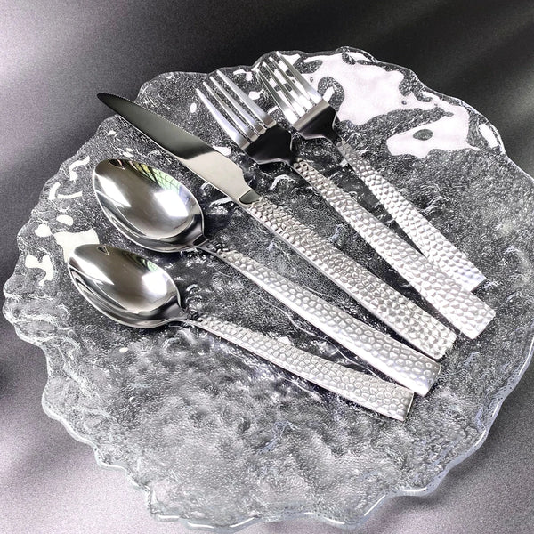 5-Piece Silverware Set displayed on a glass plate, featuring stainless steel flatware with textured handles.