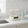 Double Cup Portable Mini Washing Machine on a countertop with bottles and towels nearby.