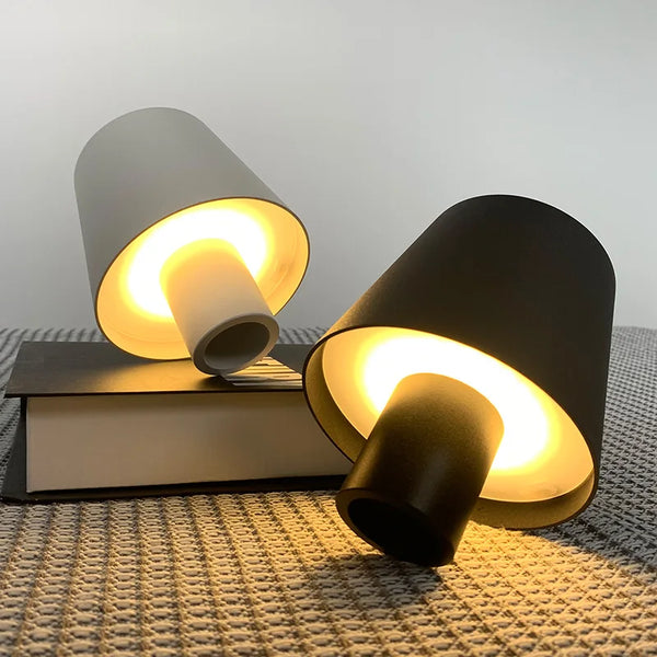 Portable LED touch table lamp on books, showcasing elegant design and adjustable warm lighting.