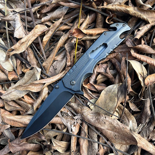 4-Function Portable Stainless Steel Survival Knife on dry leaves, showcasing its sleek design and sharp blade.