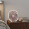 Fresh Color Box Desk USB Fan Rechargeable Cooling Fan on a bedside table next to stacked books.