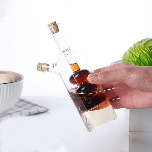 2 in 1 Olive Oil Vinegar Bottle Dispenser held in hand with dark and light liquids for kitchen use.