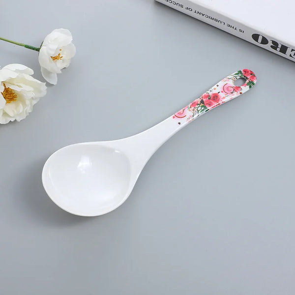 Ceramic Flower Handle Soup Spoon with floral design on handle against a gray background.