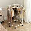 Rotating Clothes Rack with Wheels displaying various garments in a modern room with natural light and stylish decor.