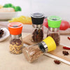 Manual Stainless Steel Pepper & Salt Grinder Mill set with colorful lids and spices in a kitchen setting.
