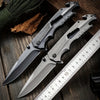 High Hardness Steel Folding Survival Pocket Knife displayed on a wooden table with a ruler and natural elements.