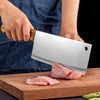 Person using a Heavy Duty Stainless Steel Bone Chopping Butcher Cleaver on a cutting board with meat.