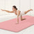 Thick Solid Yoga Mat for Fitness in use by a woman performing an exercise on a pink mat.