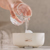 User pouring water into the 400ml Ultrasonic Essential Oil Diffuser with Remote Control.