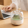 400ml Ultrasonic Essential Oil Diffuser with Remote Control releasing mist next to a laptop on a desk.