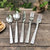 5-Piece Silverware Set Stainless Steel Flatware with stylish textured handles on wooden table.