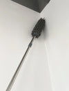 Telescopic Microfiber Removable Duster reaching high corner for effective dusting.