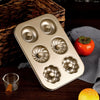 Non-Stick 6-Cavity Mini Fluted Tube Pan with various fluted designs for baking individual desserts.
