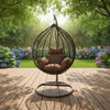Modern Indoor-Outdoor Swing Chair in a serene garden setting with colorful flowers and lush greenery.