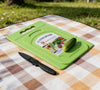 Mini Kitchen Chopping Board with Knife placed on a picnic blanket with a cucumber and a knife next to it.