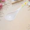 Ceramic Flower Handle Soup Spoon on a decorative surface with roses and elegant design elements.