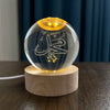 Crystal Milky Way LED Globe - 8 cm featuring illuminated engraving, set on a wooden base, creating a cozy ambiance.