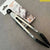 Durable Stainless Steel and Silicone Kitchen Tong displayed with packaging on a grey surface.