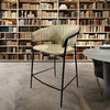 Upholstered Bar Stool with Curved Back and Black Metal Frame in a stylish interior with bookshelves.
