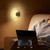 Round Portable Rechargeable Sensor Night Light in use, providing gentle illumination while a person reads.