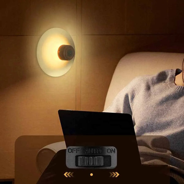 Round Portable Rechargeable Sensor Night Light in use, providing gentle illumination while a person reads.