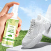 Shoe Deodorant Spray in hand next to a white sneaker on a grassy background, designed to eliminate shoe odors.