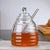 Hand-Blown Bee-Shaped Borosilicate Glass Honey Jar with a sleek design and a convenient honey dipper.