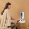 A woman using the 1200W PTC Portable Tower Heater & Cooling Fan while sitting comfortably on a sofa.