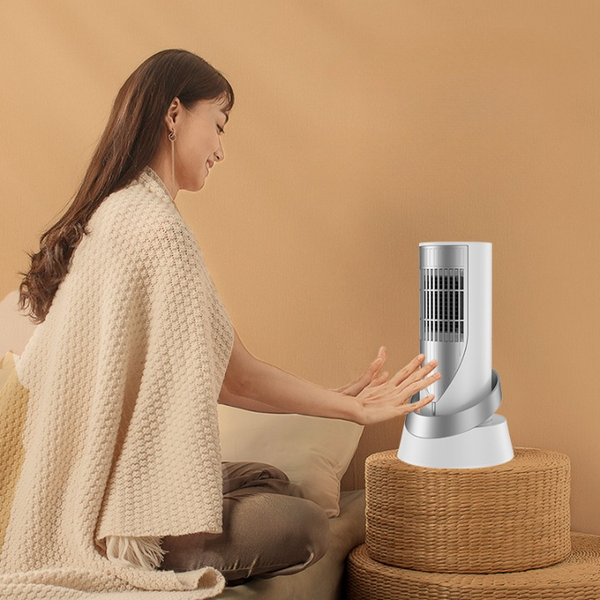 A woman using the 1200W PTC Portable Tower Heater & Cooling Fan while sitting comfortably on a sofa.