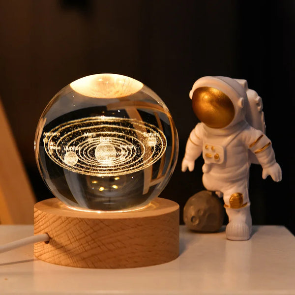 Crystal Milky Way LED Globe – 6 cm resting on wooden base with astronaut figurine beside it.