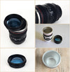 Camera Lens Travel Mug with Lid shown alongside real camera lenses, highlighting its unique design and functionality.