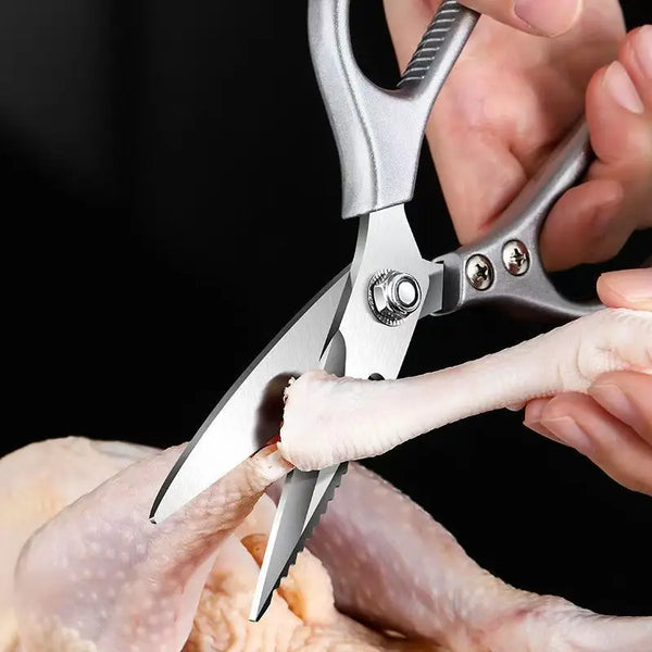Using Multi-Function Stainless Steel Kitchen Scissors to cut poultry in a kitchen setting.