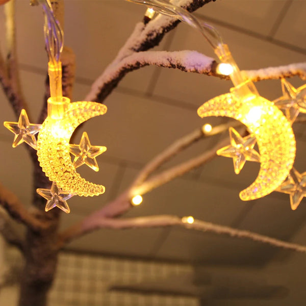 LED moon and star Ramadan string hanging light illuminating a tree with warm glowing decorations.